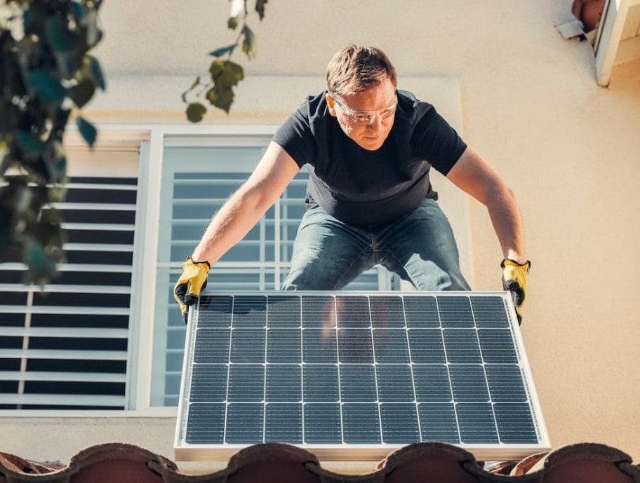A person installing solar panels on their private residence to help gain significant cost savings and reduce their carbon footprint.