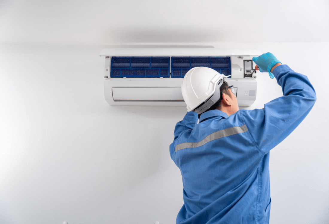  A skilled air conditioning technician repairing an office air conditioning unit, highlighting the importance of professional maintenance to ensure a comfortable and efficient work environment.